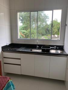 a kitchen with a sink and a window at Loft Juquehy in São Sebastião