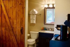 een badkamer met een toilet, een wastafel en een houten deur bij Lantern Light Inn - Romantic Getaway in Sedona