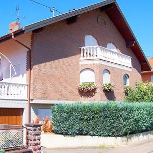 ein großes Backsteinhaus mit zwei Fenstern und einem Balkon in der Unterkunft Gästehaus Ullmannshof in Kirchheim am Neckar