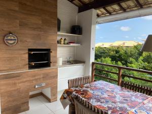 a balcony with a table and a kitchen with a view at Reserva Imbassai Apartment in Imbassai