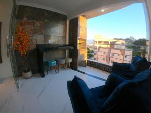 a living room with a fireplace and a large window at TH Flats GV Shopping 502 in Governador Valadares