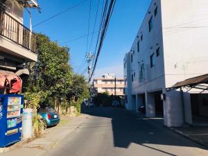 een lege straat met een auto aan de zijkant van een gebouw bij Guesthouse & Hotel RA Kagoshima in Kagoshima