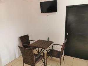 una mesa y sillas con TV en la pared en Hotel Vive Uvita, en Uvita