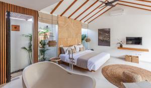 a bedroom with a bed and a tub in a room at Beyond Bespoke Villas in Seminyak
