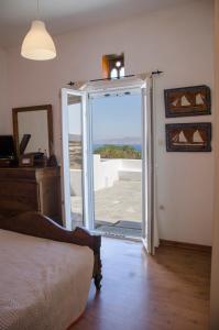 um quarto com uma porta que abre para uma varanda em Balcony to the Aegean em Stení