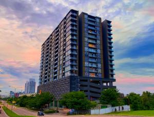 um prédio alto e preto com um pôr do sol ao fundo em Cube 8teens by Nest Home em Johor Bahru