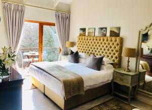 een slaapkamer met een groot bed en een balkon bij Aan De Vliet Guest House in Stellenbosch