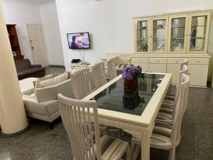 uma sala de estar com uma mesa de vidro e cadeiras em LADO DO METRÔ COPA 4 quartos no Rio de Janeiro
