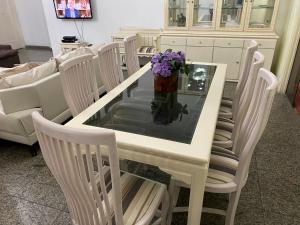 uma mesa branca com cadeiras e um vaso de flores roxas em LADO DO METRÔ COPA 4 quartos no Rio de Janeiro