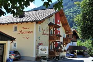 a hotel in the mountains with cars parked in front of it at Pension Posauner in Dorfgastein