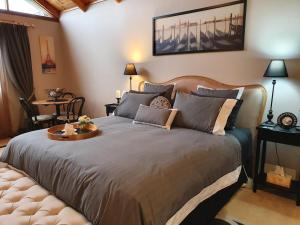 a bedroom with a large bed with a table on it at La Maison Riviere - THE RIVER HOUSE Bed & Breakfast in Goolwa