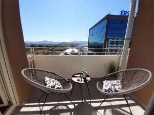 two chairs and a table on a balcony at Wonderful Apartment near City Mall in Podgorica
