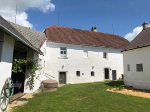 a large white building with a yard in front of it at Historic Farmhouse Kojetice in Kojetice