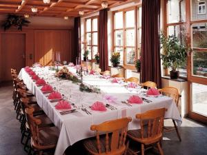 a long table with pink napkins on it in a room at Hotel Lamm in Höchberg