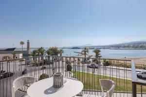 un tavolo e sedie su un balcone con vista sull'acqua di V77 Seafront Suites a Rethymno