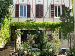 a house with a garden in front of it at Le studio du botaniste in Giverny