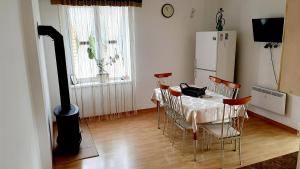 una cucina con tavolo, sedie e frigorifero di Оселя Східниця a Skhidnytsia
