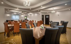 a conference room with tables and chairs and a chandelier at Vila Alexandra Sovata in Sovata