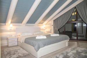 a bedroom with a large bed and a large window at Adele in Mizhhirʼʼya