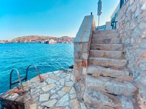 un conjunto de escaleras de piedra junto al agua en Villa Amalia, en Halki