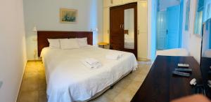 um quarto com uma cama branca e toalhas em Villa Amalia em Halki