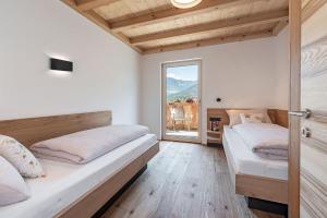 1 Schlafzimmer mit 2 Betten und einem großen Fenster in der Unterkunft Foreserhof in Völs am Schlern