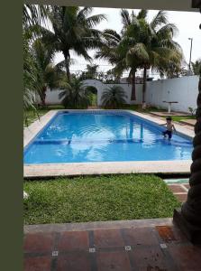 un niño está jugando en una piscina en Hotel Villa Palmeras, en Tecolutla