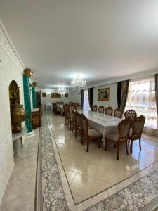 a dining room with a long table and chairs at Hotel Astam in Kostanay