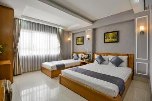 a hotel room with two beds and two lamps at Lucky Star Hotel 146 Nguyen Trai in Ho Chi Minh City