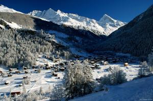 un pequeño pueblo en la nieve con montañas cubiertas de nieve en Hôtel Dents de Veisivi, en Haudères