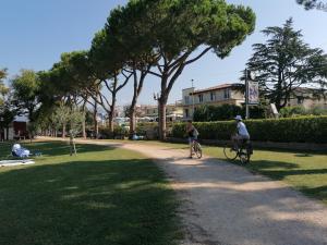 two people riding bikes down a path in a park at LA CASA DI MARZIA in Bardolino