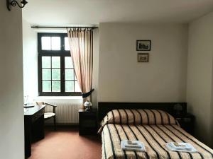 - une chambre avec un lit, un bureau et une fenêtre dans l'établissement Zamek Nidzica, à Nidzica