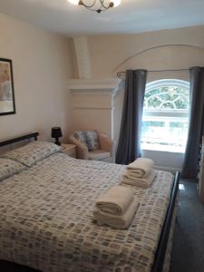 - une chambre avec un lit et des serviettes dans l'établissement Victoria Bar Apartments, à York