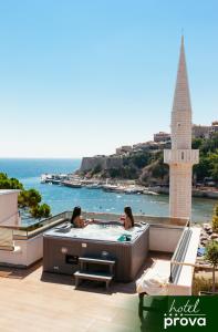 twee vrouwen in een bubbelbad op een balkon met uitzicht op de oceaan bij Hotel Prova in Ulcinj
