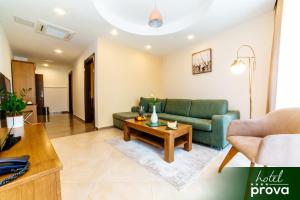 uma sala de estar com um sofá verde e uma mesa de centro em Hotel Prova em Ulcinj