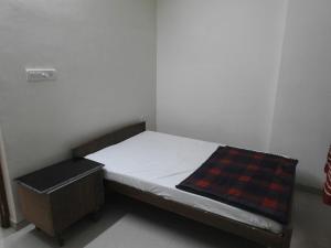 - un petit lit dans une petite chambre avec un matelas dans l'établissement Golden oriole cottage, à Mount Âbû