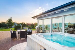 - un bain à remous sur une terrasse avec une table et des chaises dans l'établissement TERVEYS residence, à Vělopolí