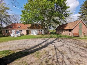an old farm house with a tree and its shadow at Gutshaus Thorstorf FeWo Groß Schwansee in Warnow
