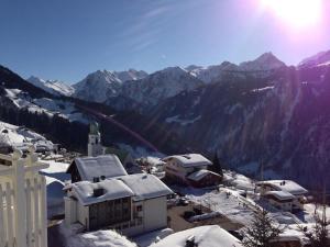 a village with snow covered buildings and a mountain at Sonnegg in Fontanella