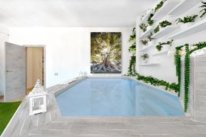 a swimming pool in a house with a painting on the wall at Penthouse Station Luxury Suites & Apartment in Brindisi