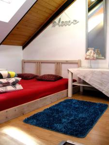 a bedroom with a red bed and a blue rug at Trend Apartment Old Market Rzeszów in Rzeszów