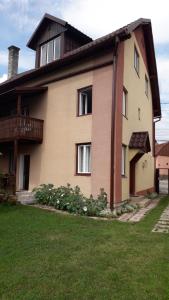 a house with a grass yard in front of it at Pensiunea Shalom in Sîncraiu