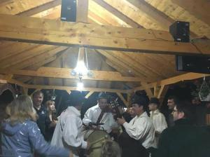 a group of people standing around in a room at Pensiunea Malinul in Bîrsana