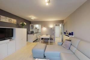 sala de estar con sofá azul y cocina en Studio met zeezicht op Heldenplein, en Knokke-Heist