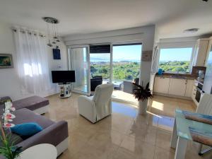 a living room with a couch and chairs and windows at Apartment Marinela in Krk