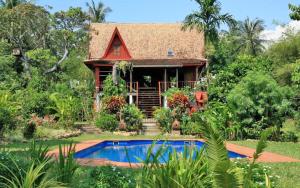 a house with a swimming pool in front of it at Piman Pu in Ko Jum