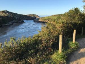 a view of a river from a hill with a fence at Albergue Internacional de Llanes in Llanes