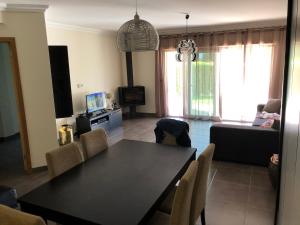 ein Wohnzimmer mit einem schwarzen Tisch und Stühlen in der Unterkunft Appartement Sao Rafael praia Algarve portugal in Albufeira