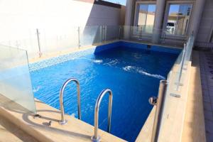 a swimming pool with blue water in a building at Al Chaffa Chalets in Ţurayf