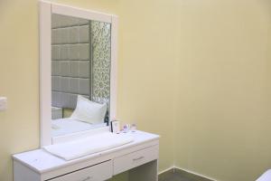 a bathroom with a white sink and a mirror at Al Chaffa Chalets in Ţurayf